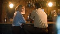 The Mallorca Files – Miranda (Elen Rhys) sitzt mit Manu Alzamora (Pablo Scola) in einer Bar, um über den Mordfall in einer Stierkampfarena zu sprechen.
