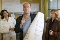 Notruf Hafenkante – Selbst im Elbkrankenhaus lässt sich Thomsen (Götz Schubert, M.) weder von Dr. Jasmin Jonas (Gerit Kling, l.) noch von seiner Frau (Johanna Gastdorf, r.) davon abbringen, weiter an seinen verrückten Plänen zu arbeiten.