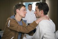 In aller Freundschaft – Marc Scholz (Michel Diercks, links) versucht Optimismus zu verbreiten. Tom Wolter (Alexander Sternberg, rechts), sein Freund, solle nicht gleich den Teufel an die Wand malen. Vielleicht ist es ja gar kein Krebs. Hans-Peter Brenner (Michael Trischan) ist es sichtlich unangenehm, die beiden Männer so vertraut zu sehen und erwähnt auch kurzerhand, dass ER nicht schwul sei.