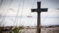 Tatort – Ein Kreuz am Strand. Im Hintergrund ist das Schiff zu sehen.