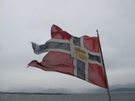 Verrückt nach Meer – Eine wehende norwegische Flagge.