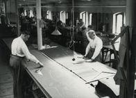 Der Nazi-Plan – Zwangsarbeiter beim Schneidern von Nazi-Uniformen. Auf ihrem Rücken errichtet die SS ein ganzes Wirtschaftsimperium.