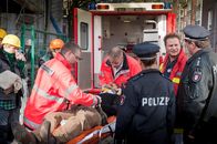 Notruf Hafenkante – Der Inhaber einer Baufirma (Niki von Tempelhoff, liegend) ist vom Gerüst gestürzt: Notarzt Haase (Fabian Harloff, 2.v.r.) informiert Franzi (Rhea Harder, 3.v.r.) und Hans (Bruno F. Apitz, r.) über den Zustand des Verletzten.