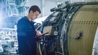 Aircraft Doctors – Aircraft Maintenance Mechanic Inspecting and Working on Airplane Jet Engine in Hangar