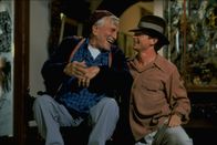Greedy - Erben will gelernt sein – Der wohlhabende Onkel Joe (Kirk Douglas, l.) wird von seiner gesamten Familie umgarnt, denn alle spekulieren auf ein großes Erbe. Danny (Michael J. Fox, r.) ist bereit, so einiges zu tun, um sich bei dem alten, gebrechlichen Mann einzuschmeicheln ...