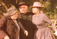 Unsere kleine Farm – Der Geduld von Reverend Alden (Dabbs Greer, M.) ist es zu verdanken, dass Kezia (Hermione Baddeley, l.) und Mrs. Oleson (Katherine McGregor, r.) in der Streitfrage um das Haus endlich zu einer Einigung kommen ...