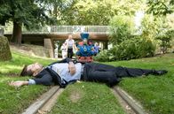 Rentnercops – Die Zugführer der Kleinbahnstrecke (Komparsen, h.) finden die Leiche des Vertreters Paul Brenner (Krisijan Rasevic, M.).