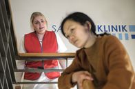 In aller Freundschaft – Anita Slotosch (Yvonne Yung Hee Bormann, re.) ist mit einer leichten Rauchgasvergiftung nach einer Gasexplosion eingeliefert worden. Doch auch ihr 12-jähriger Sohn war in dem Gebäude und sie kann einfach nicht in der Klinik bleiben, sie muss ihn suchen. Schwester Miriam (Christina Petersen, li.) versucht Anita Slotosch klarzumachen, dass sie sich jetzt erst einmal um sich kümmern muss. Und dann hat Miriam eine Idee.