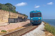Mit dem Zug ... – Einfahrt in Faro: Der Zug fährt zwischen der Lagune und der Stadtmauer der Altstadt entlang.