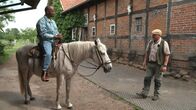 Yared kommt rum – Von Hening Koslowski (rechts) bekommt Yared eine Reitstunde auf dem Muehlenhof.