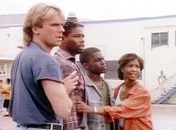 MacGyver – (v.l.n.r.) MacGyver (Richard Dean Anderson), Brian (Garvin Funches), Kelvin (Vonte Sweet) und Mrs. Jeffries (Margaret Avery) beobachten, wie ein Junge von einem Bandenmitglied zum Mitmachen überredet wird.