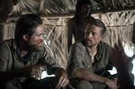 Die versunkene Stadt Z – Percy Fawcett (Charlie Hunnam, re.) und sein Assistent Henry Costin (Robert Pattinson, li.) werden von Stammesangehörigen empfangen.