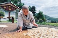 GEO Reportage – Geun Bum Sunim legt blanchierte Lotuswurzeln zum Trocknen aus.