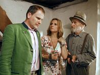Zwei Herzen und ein Edelweiß – Der gewitzte Gutsverwalter Karl (Peter Mitterrutzner, re.) schlägt das Käuferpärchen Rodenberg (Kim Fisher und Thomas Limpinsel) mit Schreckensgeschichten in die Flucht.