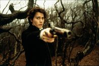 Sleepy Hollow - Köpfe werden rollen – Ichabod Crane (Johnny Depp) nimmt inmitten eines Waldstücks eine mysteriöse Gestalt auf einem weißen Pferd wahr, auf die er seine Waffe richtet.