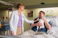 In aller Freundschaft – Dr. Ina Schulte (Isabell Gerschke) schaut nach dem frischgebackenen Vater Artur Martens (Knud Riepen) und dem kleinen Ilay.