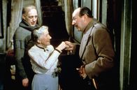 Ladykillers – Mrs. Wilberforce (Katie Johnson, Mi.) ahnt nicht, dass Professor Marcus (Alec Guinness, li.) mit seinen Kumpanen, unter anderem Claude (Cecil Parker, re.), in ihrem Haus einen Geldraub plant.
