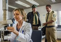 Hubert und Staller – Monika Bösmeier (Isabella Leicht, links) vom Wasserwirtschaftsamt Weilheim erklärt sich bereit, die Wasserprobe von Hubert (Christian Tramitz, rechts) und Staller (Helmfried von Lüttichau, Mitte) zu analysieren.