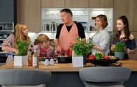 In aller Freundschaft – Roland Heilmann (Thomas Rühmann, mi.) hat in seiner glücksgefüllten Euphorie sowohl alle Mitglieder seiner Familie als auch die von Katja Brückner (Julia Jäger, 2.v.re.) zum Essen eingeladen. Kochen will er selbst. Da sich Roland damit jedoch zeitlich komplett übernommen hat, ist er froh, dass alle mit anpacken. v.li.: Lisa Schroth (Ella Zirzow), Hanno Brückner (Kasimir Brause), re.: Emma Brückner (Vivien Sczesny)