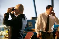 Mayday - Alarm im Cockpit – REENACTMENT - The Tenerife Controller (played by Rodrigo Fernandez-Stoll) is on the phone and the Junior Investigator (played by background performer Marcelo Pinero) looks out the tower through binoculars. (Photo Credit: Cineflex/Ian Watson)