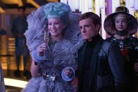 Die Tribute von Panem - Catching Fire – Stolz präsentiert Effie (Elizabeth Banks, l.) auf dem Empfang in der Hauptstadt ihren Gewinner Peeta (Josh Hutcherson, M.). Doch ihr Glücksgefühl wird ihr schon bald genommen ...