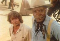 Unsere kleine Farm – Für die opulente Garderobe von Mrs. Oleson haben Charles (Michael Landon, l.) und Joe (Moses Gunn, r.) nur abschätzige Blicke übrig.