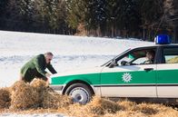 Hubert ohne Staller – Girwidz (Michael Brandner, l.) ist ungeduldig und möchte trotz defekter Bremse mit dem Streifenwagen weiterfahren. Hubert (Christian Tramitz, r.) sitzt im Auto und lenkt.
