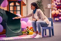Ruby – Gilda (Sogol Faghani) reicht Ruby, die in einer Rutsche feststeckt, ihr Handy. David möchte sie sprechen.
