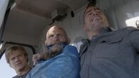 MacGyver – Auf dem Weg den festgenommenen Kriegsverbrecher Victor (Keith Jardine , M.) in die Heimat zu fliegen, stürzt Macs (Lucas Til, l.) und Jacks (George Eads, r.) Helikopter über einem abgelegenen Gebiet in Kasachstan ab. Dabei wird ihre Pilotin verletzt und der Gefangene kann mit Jacks Waffe entkommen