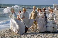 Buddenbrooks – Die feine Lübecker Gesellschaft, angeführt von Senatorin Möllendorpf (Sunnyi Melles, li.) und ihrem Gatten Senator James (Josef Ostendorf, 3.v.l.), beäugt am Strand von Travemünde misstrauisch Tonys Affäre mit Morten Schwarzkopf.