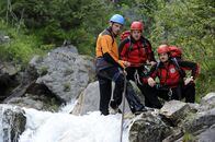 Die Bergretter – Andreas Marthaler (Martin Gruber, l.), Toni Stössl (Martin Klempnow, M.) und Tobias Herbrechter (Markus Brandl, r.) seilen sich an der Rotbach, einem reißenden Wildbach ab, um weiter nach dem offensichtlich verunglückten Hannes zu suchen. Hat ihn der Fluss mitgerissen?