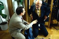 Löwenzahn Classics – Peter (Peter Lustig, r.) möchte den Anzug, den er sich für sein Fest gekauft hat, gleich anbehalten. Der Verkäufer (Boris Aljinovic, r.) ist entsetzt darüber, dass Peter seinen gesamten Krimskrams aus der Latzhose in den Anzugtaschen unterbringen will.