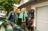 Hubert ohne Staller – Hubert (Christian Tramitz, l.) und Girwidz (Michael Brandner, M.) bringen den betrunkenen Wiesngänger Spyros Karamanlis (Nikos Laskari, r.) zu seiner Unterkunft.