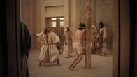 Universum History – Ein Mann ist an einen Pfahl gefesselt und wird von einem anderen mit einem Stock verprügelt.