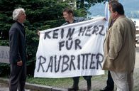 Die Rosenheim-Cops – Bei der Besichtigung des Tatorts werden die beiden Cops (Joseph Hannesschläger, vorne r., Markus Böker, verdeckt) Zeuge des Nachbarschaftsstreit, den Hotelier Buxner (Mathieu Carriere, l., mit Andreas Anstedt, mi.) seit Jahren mit seinem Nachbarn austrägt.