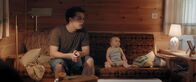 Windstill – Rafael (Anselm Bresgott) und Baby Olivia (Patricia Graf) sitzen auf dem Sofa.