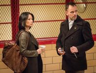 Elementary – Während Holmes (Jonny Lee Miller, r.) und Watson (Lucy Liu, l.) einen lange zurückliegenden Fall aufrollen müssen, geht ihnen Lestrade auf die Nerven, denn er macht keine Anstalten, die beiden wieder zu verlassen ...