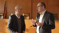 SMS - Schwanke meets Science – moderator Karsten Schwanke und Prof. Dr. Christian Hesse im Verhandlungssaal des Bundesverfassungsgerichts in Karlsruhe.