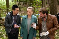 Rentnercops – Dezernatsleiterin Vicky Adam (Katja Danowski, M.), ihr neuer Kommissarsanwärter Hui Ko (Aaron Le, l.) und Pathologe Dr. Oliver Körfer (Peter Trabner, r.) am Fundort der Leiche im Wald. Beim Skelett wird Geld gefunden, das aus der Vereinskasse eines Karnevalskasse stammt, wie sich schnell herausstellt.