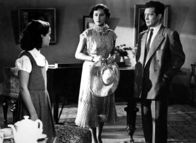 Das doppelte Lottchen – Lotte (Jutta Günther, l.), die als Luise zu ihrem Vater Ludwig (Peter Mosbacher) nach Wien gefahren ist, mag dessen Freundin Irene (Senta Wengraf, Mitte) gar nicht.