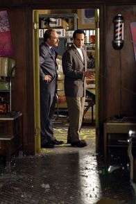 Monk – In einem Friseursalon, in dessen Hinterzimmer illegal Glücksspiel betrieben wird, kommt es zu einer Schießerei. Captain Leland Stottlemeyer (Ted Levine, l.) und Adrian Monk (Tony Shalhoub, r.) untersuchen den Tatort ...