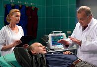 In aller Freundschaft – Prof. Dr. Gernot Simoni (Dieter Bellmann, rechts) versucht den Herzkranken Dietmar Bloch (Bernd Michael Lade, liegend) zu überzeugen, seine Medikamente wieder einzunehmen, da sonst sein Vorhofflimmern nicht mehr kontrollierbar ist. Dem arbeitslosen Busfahrer scheint aber alles gleichgültig. Oberschwester Ingrid (Jutta Kammann) muss Blochs Zustand genau im Auge behalten.