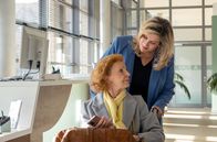 In aller Freundschaft – Ingrid Rischke (Jutta Kammann, sitzend) ist in der Sachsenklinik, um eine Stenose der Beinarterie behandeln zu lassen. Als Sarah Marquardt (Alexa Maria Surholt, oben) dies erfährt, wird sie hellhörig und wittert finanzielle Unterstützung. Schließlich spielt die ehemalige Oberschwester noch immer eine wichtige Rolle in der Simoni-Stiftung.