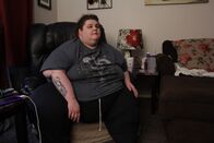 Mein Leben mit 300 kg – Sarah sits on her chair at home.