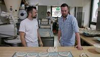 Brotzeit – Rechtsschlinger oder Linksschlinger? Brezel-Recherche des Wildbakers Jörg Schmid (li.) beim Brezelbäcker Francesco (li.) in Stuttgart.