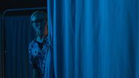 Die Geisterkliniken – A frightened nurse looks behind the curtain.