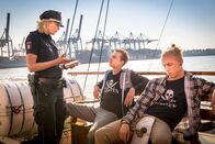 Notruf Hafenkante – Adrian und Friedrich erzählen Melanie (Sanna Englund), dass sie die Galionsfigur stehlen wollten, weil die Wirtin der "Elbnixe“ mit ihren 3000 Euro durchgebrannt ist, die sie für ihre bevorstehende Abifeier bereits bezahlt hatten.