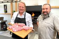 Der Vorkoster – Gemeinsam mit Grillweltmeister und Fleischsommelier Oliver Sievers (r) bereitet Björn Freitag Koteletts und saftige Spareribs auf dem Grill zu.