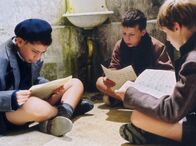 Die Kinder des Monsieur Mathieu – Der Lausejunge Pierre Morhange (Jean-Baptiste Maunier, rechts) hat mit seinen Mitschülern Corbin (Thomas Blumenthal, links) und Le Querrec (Cyril Bernicot) die Noten seines Lehrers Mathieu gestohlen. Auf der Toilette betrachten die drei Jungs etwas ratlos ihre rätselhafte Beute.