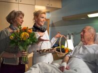 In aller Freundschaft – Oberschwester Ingrid Rischke (Jutta Kammann, mi.) und Barbara Grigoleit (Uta Schorn, li.) wollen sich bei Emil Lerchfeld (Otto Mellies, re.) entschuldigen. Barbara fühlt sich verantwortlich für seinen Klinikaufenthalt. Emil Lerchfeld jedoch ist den beiden Damen für ihr beherztes Eingreifen bei der Pressekonferenz dankbar.